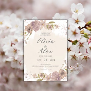 May include: A wedding invitation with a watercolor floral design in shades of pink and green. The invitation features the names "Olivia & Alex" and the date "Oct 23, 2024". The text "Wedding Invitation" and "Save the Date" are also included. The invitation is set against a background of white and gold splatters.