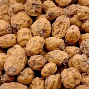 May include: A pile of tiger nuts, also known as chufa nuts, with a light brown color and a textured surface. These edible tubers are a popular snack and ingredient in various cuisines.