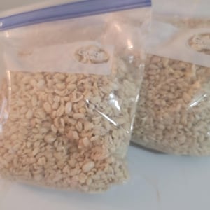 May include: Two clear plastic bags filled with white, dried, and chopped garlic cloves.