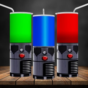 Puede incluir: Tres vasos de acero inoxidable con un diseño de robot. Los vasos son verde, azul y rojo.