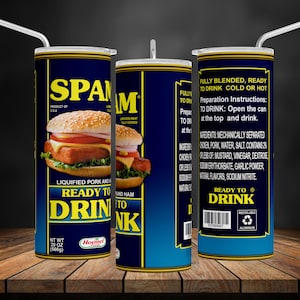 Könnte beinhalten: Eine blaue und gelbe Dose mit dem Wort "SPAM" in weißen Buchstaben. Die Dose zeigt ein Bild eines Spam-Sandwiches. Die Dose ist mit "Ready to Drink" beschriftet und hat ein Bild eines Strohhalms, der aus der Oberseite herausragt. Die Dose steht auf einer Holzoberfläche.