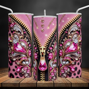 May include: A pink and gold tumbler with a zipper design and rhinestones. The tumbler has a leopard print pattern on the bottom.
