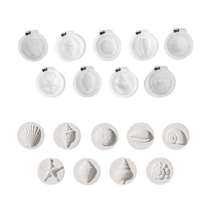 Op de afbeelding: Witte schelpvormige mallen en ronde schelpontwerpen. De mallen hebben een kleine zwarte clip aan de bovenkant. De ronde ontwerpen tonen verschillende schelptypes, waaronder een zeester, een koker en spiraalschelpen. Ideaal voor knutselen of kustdecoratie.