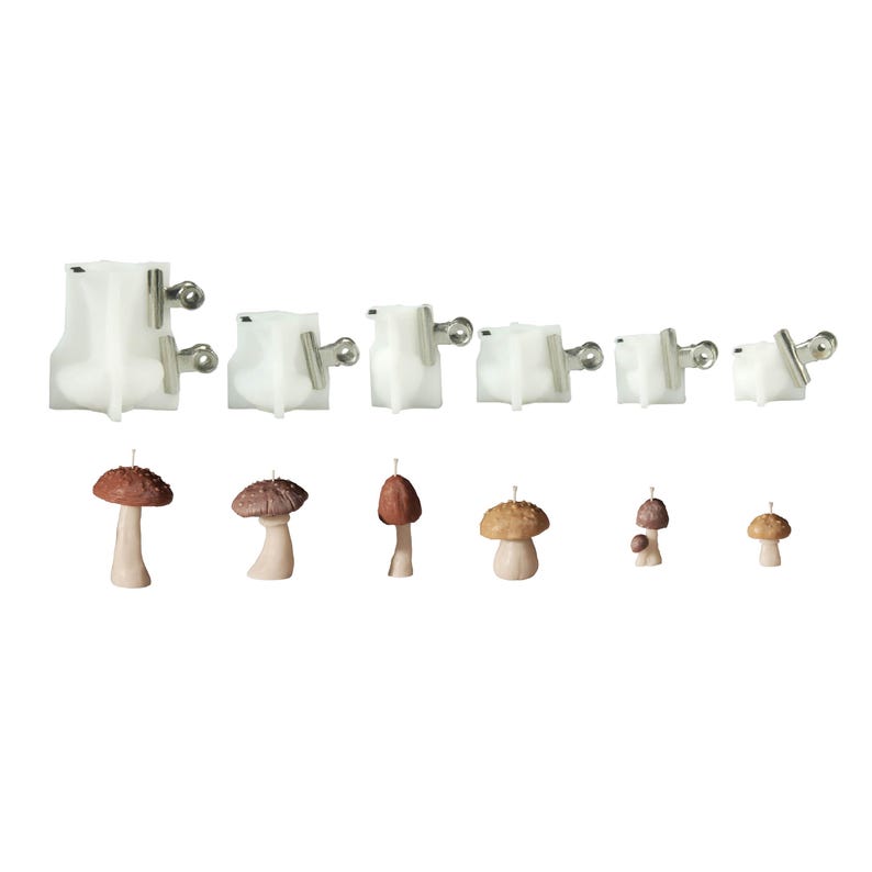 May include: A collection of six translucent white silicone molds for casting mushroom shapes, each secured with metal binder clips, displayed alongside six finished brown and beige mushroom-shaped candles of varying sizes and cap textures.