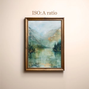 Pode incluir: Uma pintura emoldurada que representa uma cena de lago de montanha nebulosa com &aacute;rvores verdes e o reflexo das montanhas na &aacute;gua. A pintura est&aacute; em uma moldura de madeira.