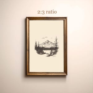 May include: A framed black and white ink drawing of a mountain range with a lake in the foreground. The drawing is in a wooden frame with a white mat. The text "2:3 ratio" is printed above the drawing.