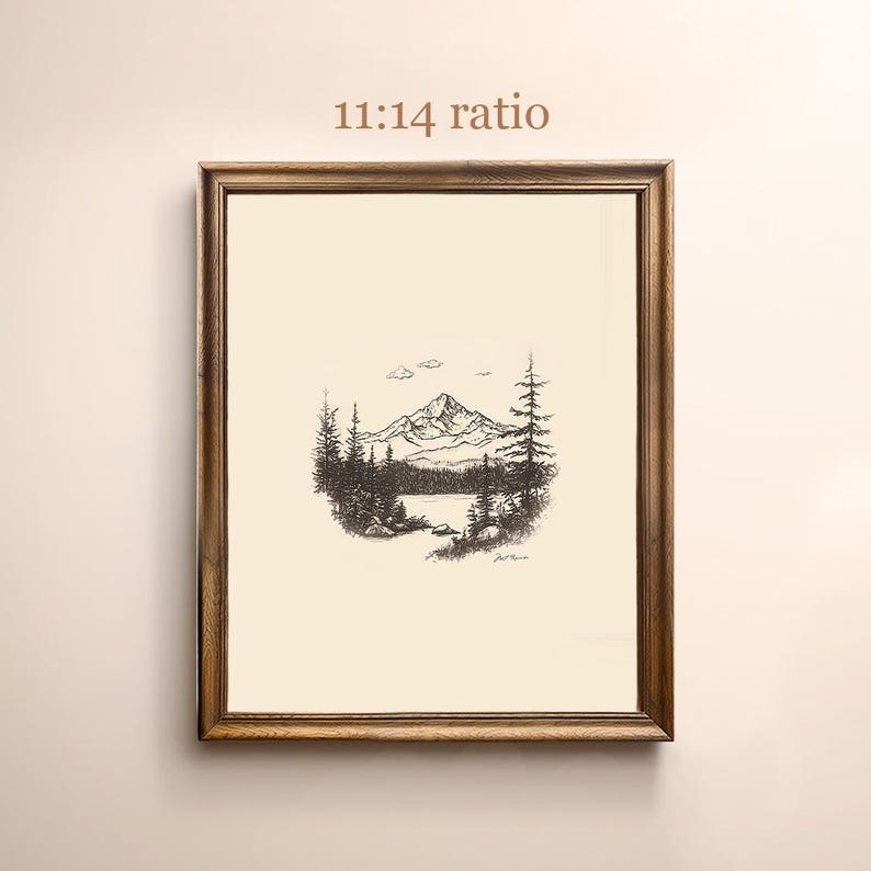 May include: A black and white line drawing of a mountain scene with a lake in the foreground. The drawing is framed in a brown wooden frame. The text "11:14 ratio" is printed above the frame.