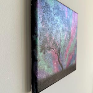 Peut inclure: Une peinture sur toile repr&eacute;sentant une silhouette sombre d'un arbre sur un fond color&eacute; de rose, violet, vert et bleu avec des &eacute;toiles blanches.