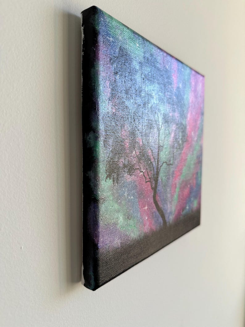 Peut inclure: Une peinture sur toile repr&eacute;sentant une silhouette sombre d'un arbre sur un fond color&eacute; de rose, violet, vert et bleu avec des &eacute;toiles blanches.