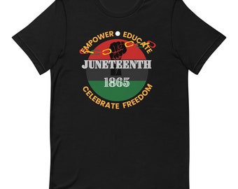 May include: A black short-sleeve t-shirt featuring a circular graphic with red, black, and green horizontal stripes. The design includes a black raised fist breaking a chain, with the text EMPOWER, EDUCATE, JUNETEENTH, 1865, CELEBRATE, FREEDOM.