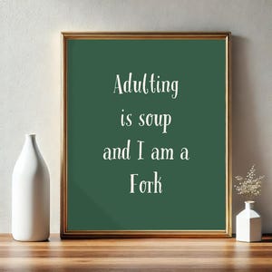 May include: A framed print with a green background and white text that reads "Adulting is soup and I am a Fork".
