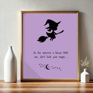 May include: A framed print with a gold border features a black silhouette of a witch on a broom against a lavender background. The text reads, "Do the universe a favour little one, don't hide your magic..." with stars and a crescent moon.