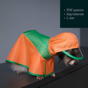 May include: A dog wearing an orange and green raincoat with a matching hood. The raincoat has a clear visor and is labeled as an L size. The image also includes text that says "PDF pattern" and "dog raincoat".