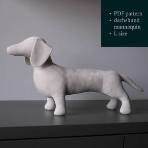 Könnte beinhalten: Ein hellgraues Dackel-Mannequin in stehender Pose. Der Hund hat Schlappohren und einen langen Körper. Der Text auf dem Bild lautet: PDF-Muster, Dackel-Mannequin, Größe L.