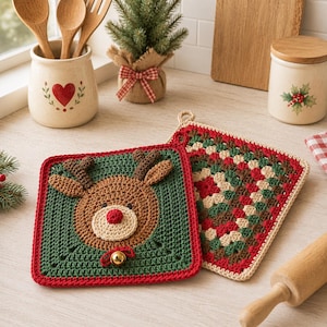 Op de afbeelding: Twee handgemaakte gehaakte pannenlappen. Eén is groen met een rendiergezicht, rode rand en een kleine gouden bel. De andere is een patchwork-ontwerp in rood, groen en beige. Perfect voor vakantiekeukendecoratie.
