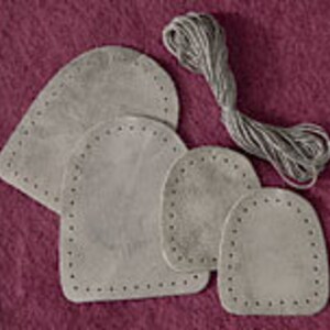 May include: Four grey leather patches with stitched edges, in various sizes, and a spool of grey thread.