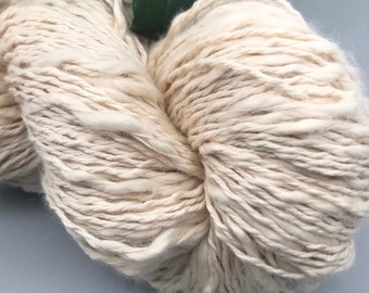 May include: A skein of off-white yarn with a fuzzy texture.