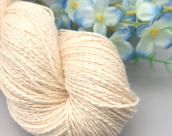 Peut inclure: Un gros plan d'une pelote de fil de coton blanc naturel. Le fil est doux et moelleux, et il est parfait pour le tricot ou le crochet.