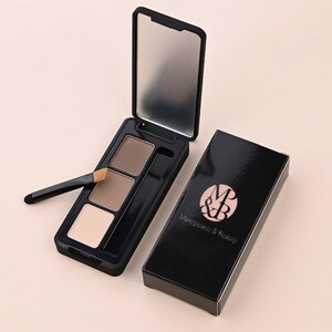 May include: A black eyebrow kit containing three shades of brown powder and a small angled brush. The kit is in a compact with a mirror and the brand name "Makeupco & Beauty" is printed on the box.