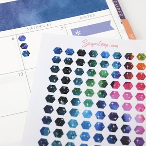 May include: A sheet of galaxy-themed hexagonal stickers with a variety of colors, including blue, green, pink, and purple. The stickers have a white background with a galaxy design and white stars.