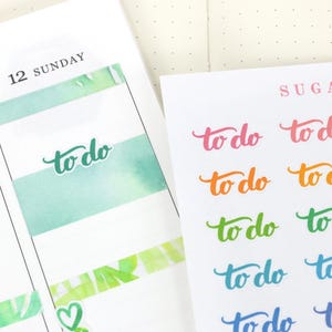Può includere: Una pagina di pianificazione con un foglio di adesivi "to do". La pagina del pianificatore mostra la data "12 DOMENICA" con un design acquerello turchese. Il foglio di adesivi ha la parola "to do" in vari colori.