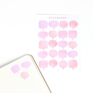 Può includere: Un foglio di adesivi a forma di fumetto in acquerello rosa e rosa chiaro. Gli adesivi sono disposti a griglia. Il foglio è etichettato "Sugarloop".