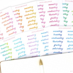 May include: A set of colorful stickers with the days of the week written in cursive script. The stickers are arranged in rows on a white surface. The text "SUGARLOOP" appears on each sheet of stickers.