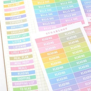 May include: A set of colorful planner stickers with various labels, including "Bills Due", "Chores", "Errands", "Expenses", "Gratitude", "Groceries", "Grocery List", "Listen To", "Listening", "Little Things", "Meal Plan", "Meal Prep", "Meals", "Reading", "Shopping", "Shopping List", and "To Read".