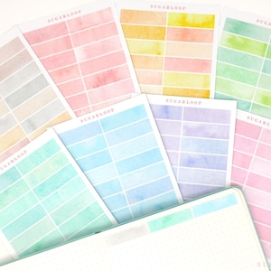 May include: A selection of watercolour sticker sheets in pastel shades of pink, blue, green, and yellow. Each sheet displays rectangular blocks of colour. The brand name "SUGARLOOP" is printed on each sheet.