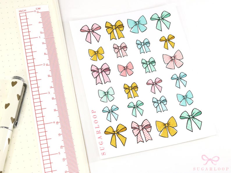 May include: A sheet of colorful bow stickers with a variety of pastel colors, including pink, blue, yellow, and green. The stickers are arranged in rows and columns on a white background. The sheet is labeled "Sugarloop" in the bottom left corner.