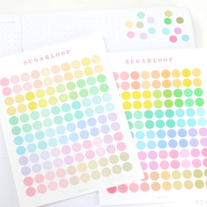 May include: Two sheets of pastel colored dot stickers with the text "SUGARLOOP" printed on each sheet. The stickers are arranged in a rainbow pattern.