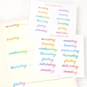 May include: Two sheets of paper with the days of the week written in rainbow colours. The words are written in a handwritten style. The text "SUGARLOOP" appears at the top of each sheet.