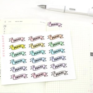 May include: A sheet of colorful 'TODAY' banner stickers. The stickers are in a variety of pastel colors, including pink, blue, green, and yellow. Each sticker features a black banner with the word 'TODAY' printed in black.