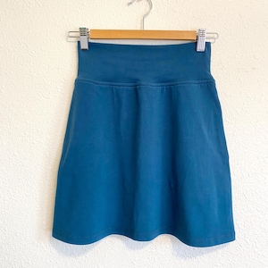 May include: A teal blue mini skirt with a wide waistband.