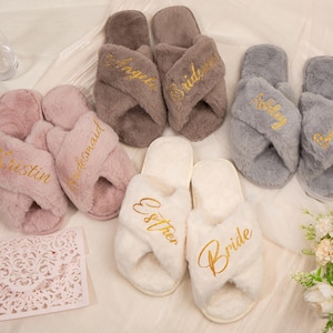 May include: Set of eight fuzzy slippers with cross-over straps. Each slipper has a different embroidered name: "Bride", "Maid of Honor", "Bridesmaid", "Kristin", "Esther", "Angela", "Riley", and "Maid of Honor".