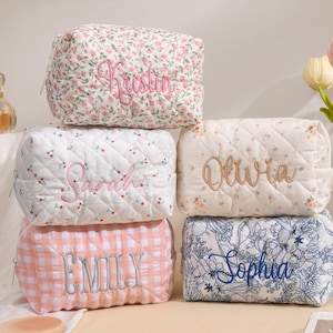 Puede incluir: Seis neceseres acolchados con varios diseños florales y estampados. Cada bolsa está bordada con un nombre en un color complementario. Las bolsas son en tonos de rosa, blanco y azul, con una estética suave y femenina.