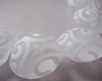 May include: A strand of translucent, frosted glass beads, each featuring a smooth, rounded shape and an opaque white pattern of swirling lines and small circular dots. The beads are strung together on a thin, clear filament thread.