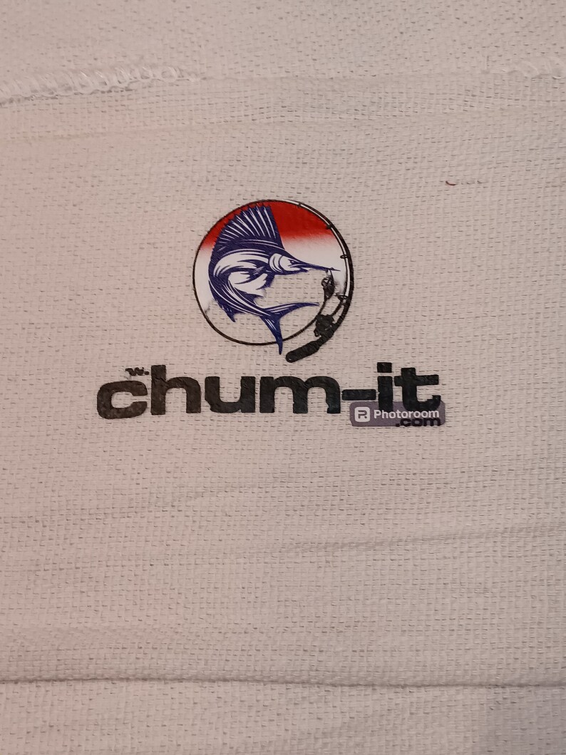 以下が含まれることがあります： 白い布地に、黒と白のロゴ「chum-it」と、赤い、白い、青いマルリンの魚のロゴが円形に描かれている。