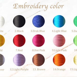 May include: A color chart displaying embroidery thread colors. The text "Embroidery color" is at the top. Fifteen color swatches are arranged in rows, each with a number and color name, including white, black, blue, green, gold, red, pink, and yellow.
