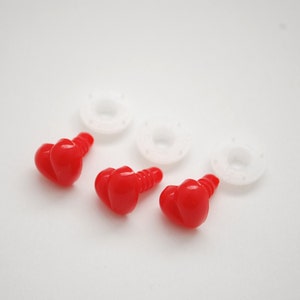 May include: Three red plastic safety eyes with a heart-shaped design, along with three white plastic washers. These craft supplies are used for making stuffed animals and other handmade projects.