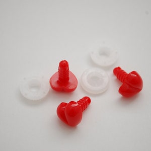 May include: Close-up of red plastic safety eyes with screw posts and white plastic washers. These craft supplies are used for making stuffed animals, dolls, and other handmade projects. The eyes are a bright, solid red color.