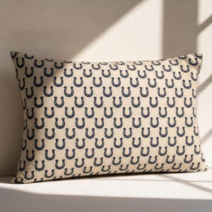 Preppy navy horseshoe lumbar pillow in sunlight, beige equestrian throw pillow, minimalist farmhouse decor accent