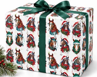 Puede incluir: Una caja de regalo rectangular envuelta en papel blanco con un patrón repetitivo de caballos marrones que llevan gorros de Papá Noel rojos, bufandas verdes y gafas, atada con un lazo de satén verde oscuro en la parte superior.
