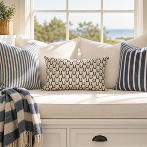 Coastal preppy window seat with horseshoe lumbar pillow, navy striped cushions, equestrian farmhouse decor styling