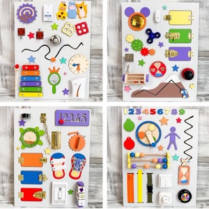 May include: Four white wooden busy boards with various interactive elements. Each board features colorful shapes, latches, gears, and other sensory components. One board includes a xylophone, another a clock, and others have numbers and letters.