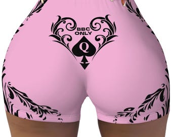 May include: Pink athletic shorts with a black floral design and the text "BBC ONLY" and a black queen of spades symbol.