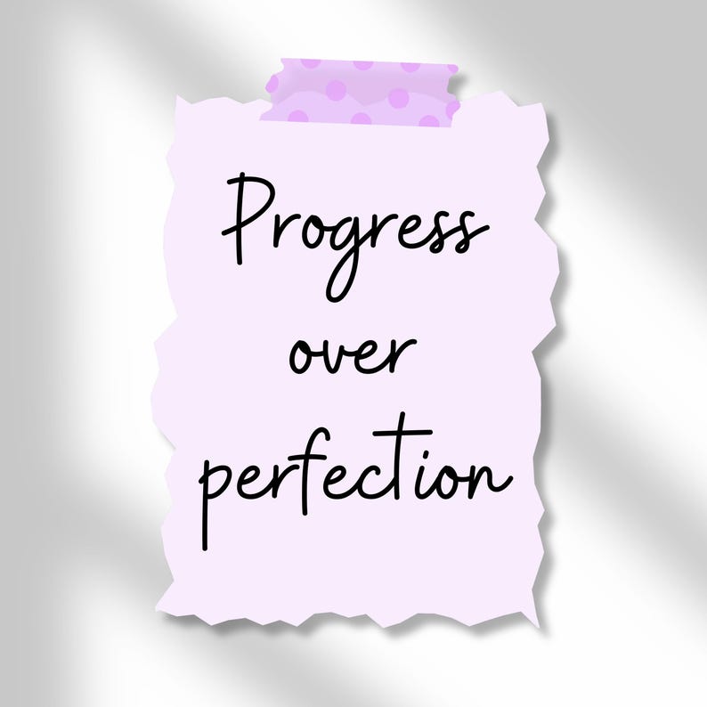Może przedstawiać: Jasnofioletowa, podarta kartka papieru z napisem "Progress over perfection" napisanym czarnym pismem. Notatka jest przymocowana kawałkiem jasnofioletowej taśmy z r&oacute;żowymi kropkami.