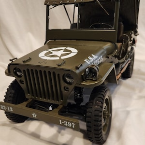 May include: A green toy jeep with a canvas top, white star and U.S.A. markings, and the numbers 1-397 on the front bumper.