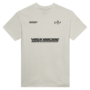 May include: A light gray t-shirt with black text that reads "VOLK RACING RAYS ENGINEERING" and "Drift Club" in cursive. The shirt also has a small logo that reads "RAYS" in the top left corner.