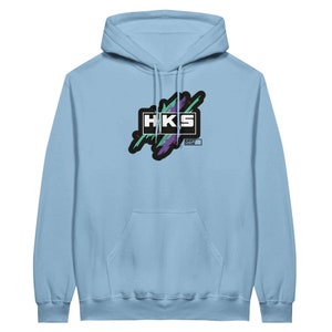 Könnte beinhalten: Hellblauer Hoodie mit einer schwarzen, lila und grünen Grafik des Textes "HKS" mit den Worten "Drift Culture" darunter.